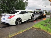 Nissan coupe being loaded on tow truck