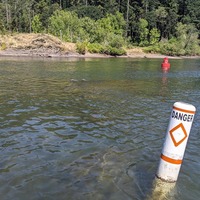 Waterway markers near Bernert Landing on the Willamette River near West Linn identifying safe navigation and danger area due to shallow water.