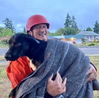 Lieutenant Michael Maynard carries the rescued dog to safety. 