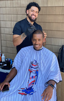 Eric Tolento provides a free haircut to actor William H. Bryant Jr. at the Maurice Lucas Foundation golf tournament.