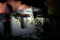Firefighters work to put out hot spots on Thursday night. 