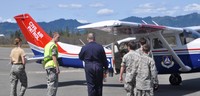 Pilot Maj Mike Wissing (blue flight suit) shows cadets features of the Cessna 206 aircraft as they board for Orientation Rides.