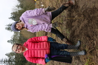 Olive Jackson and Hazel Johnson, students at Hockinson Heights Elementary School, proudly pose with a native shrub that they have freshly planted.