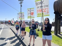 Nurses wave signs during informational picket in downtown Seaside on April 27, 2023